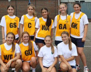 A group of girls in netball kits smiling for a photo